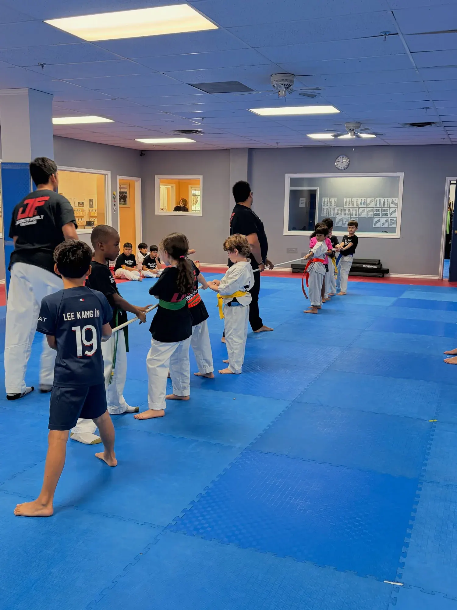 Campers play tug of war on the mats, cheered on by their instructors
