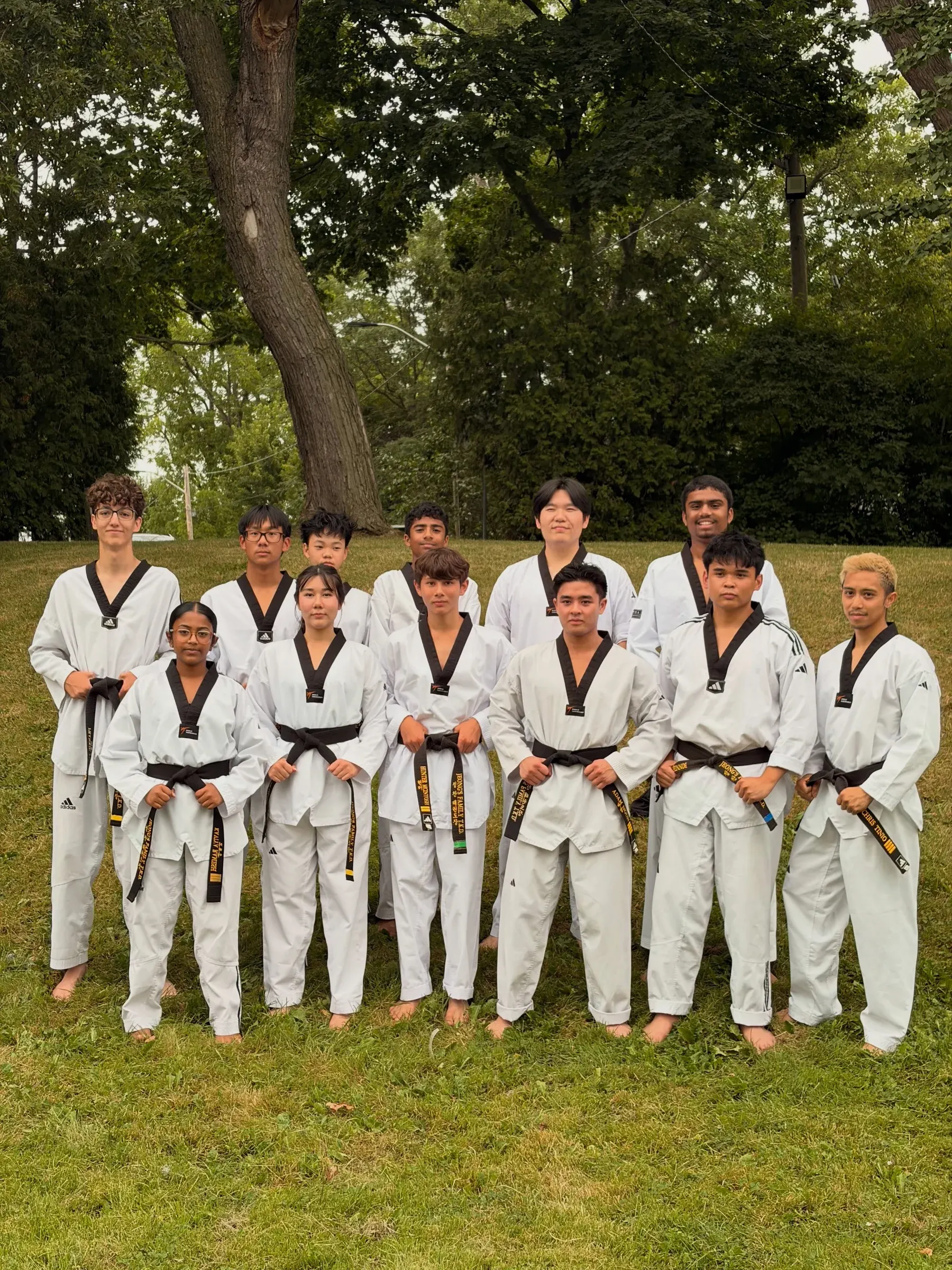 Our Demo Team in white uniforms and black belts, standing together on the grass at the Water Lantern Festival