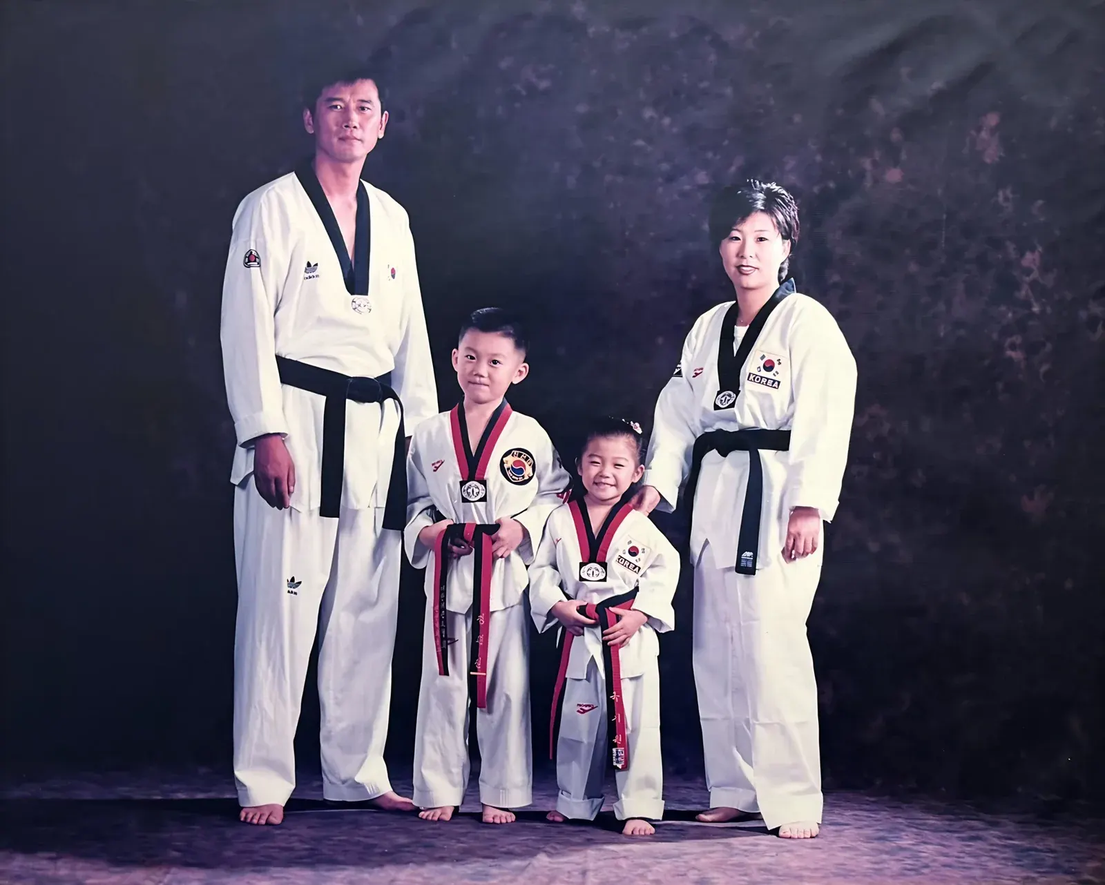 The Jeong family years ago: Grandmaster Chan Jeong, his wife and their two young children, all in taekwondo uniforms
